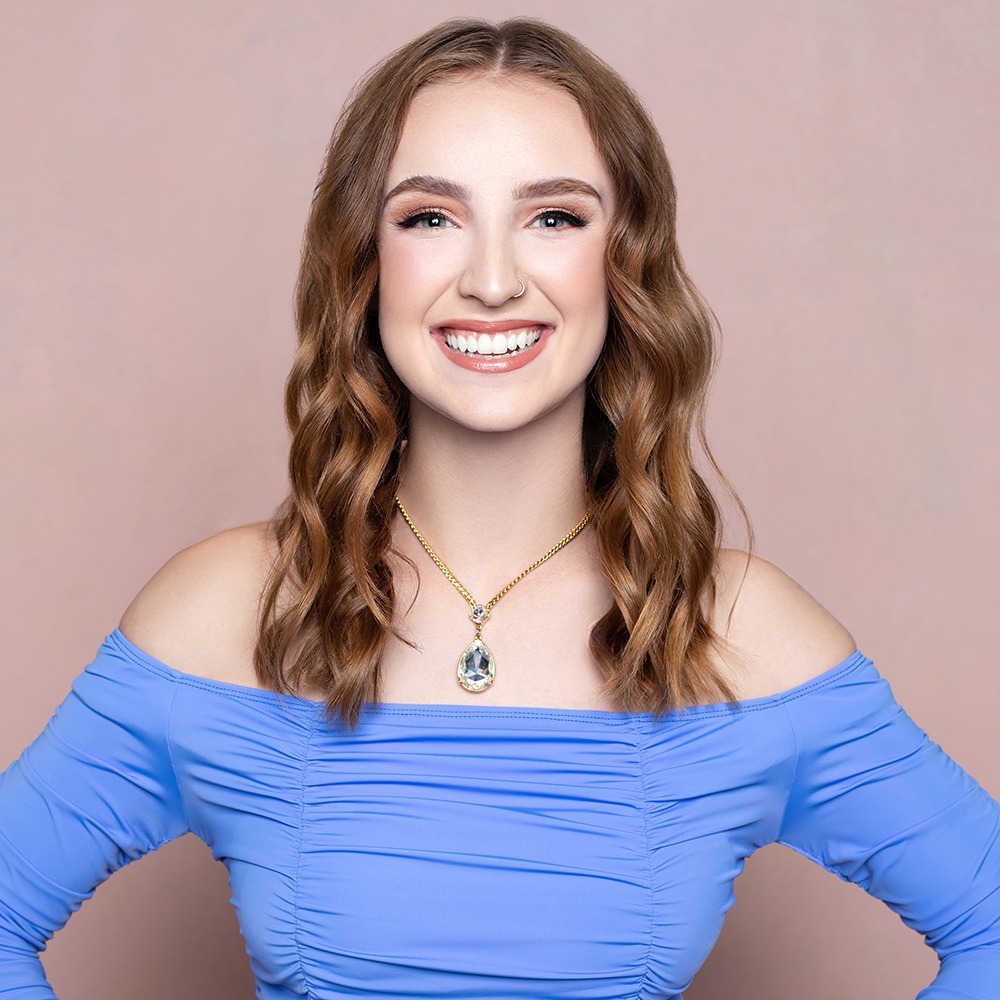 ginger haired woman in blue dress smiling